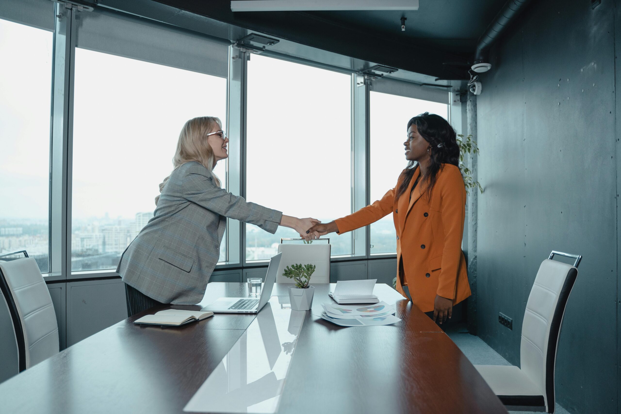 A business leader coaching a team in a modern office, engaged in a strategy session.