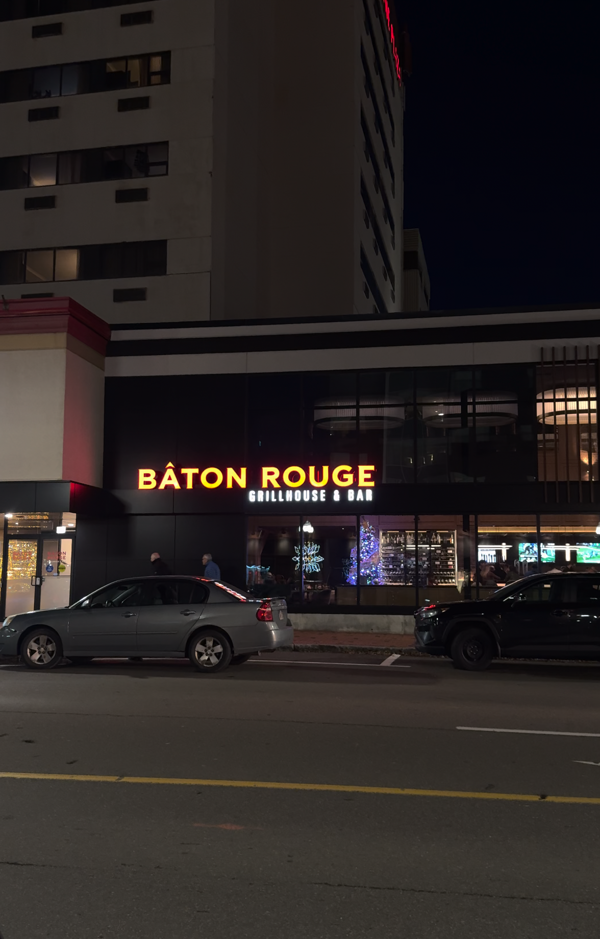 Exterior of Baton Rouge Grillhouse and Bar in downtown Moncton at night, decorated for the holidays, highlighting its location for date nights during local Christmas shopping.