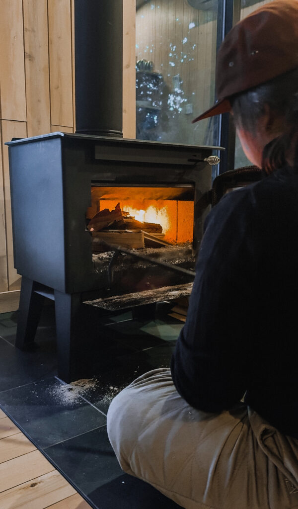 Warm wood stove with a cup of local coffee inside a luxury eco-cabin.
