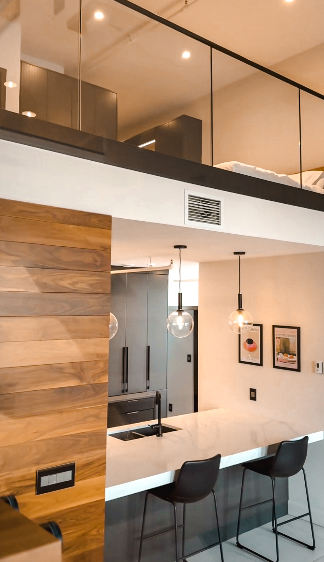 Interior of the Archibald Suite Brix Moncton showing the mezzanine bedroom above and kitchen island below
